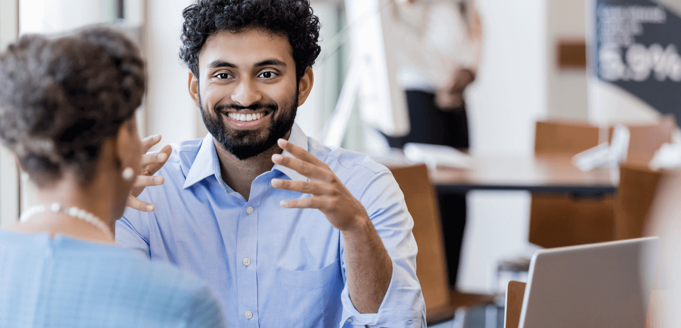 Young man of color employee talking to senior customer