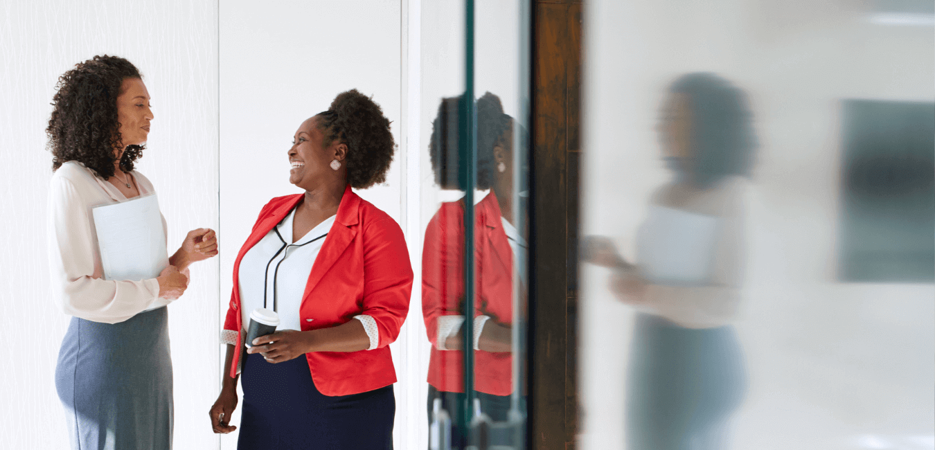 Female employees standing having conversation in office