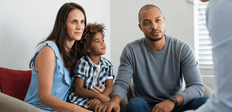 Family seated on couch, engaged in conversation with bank officer