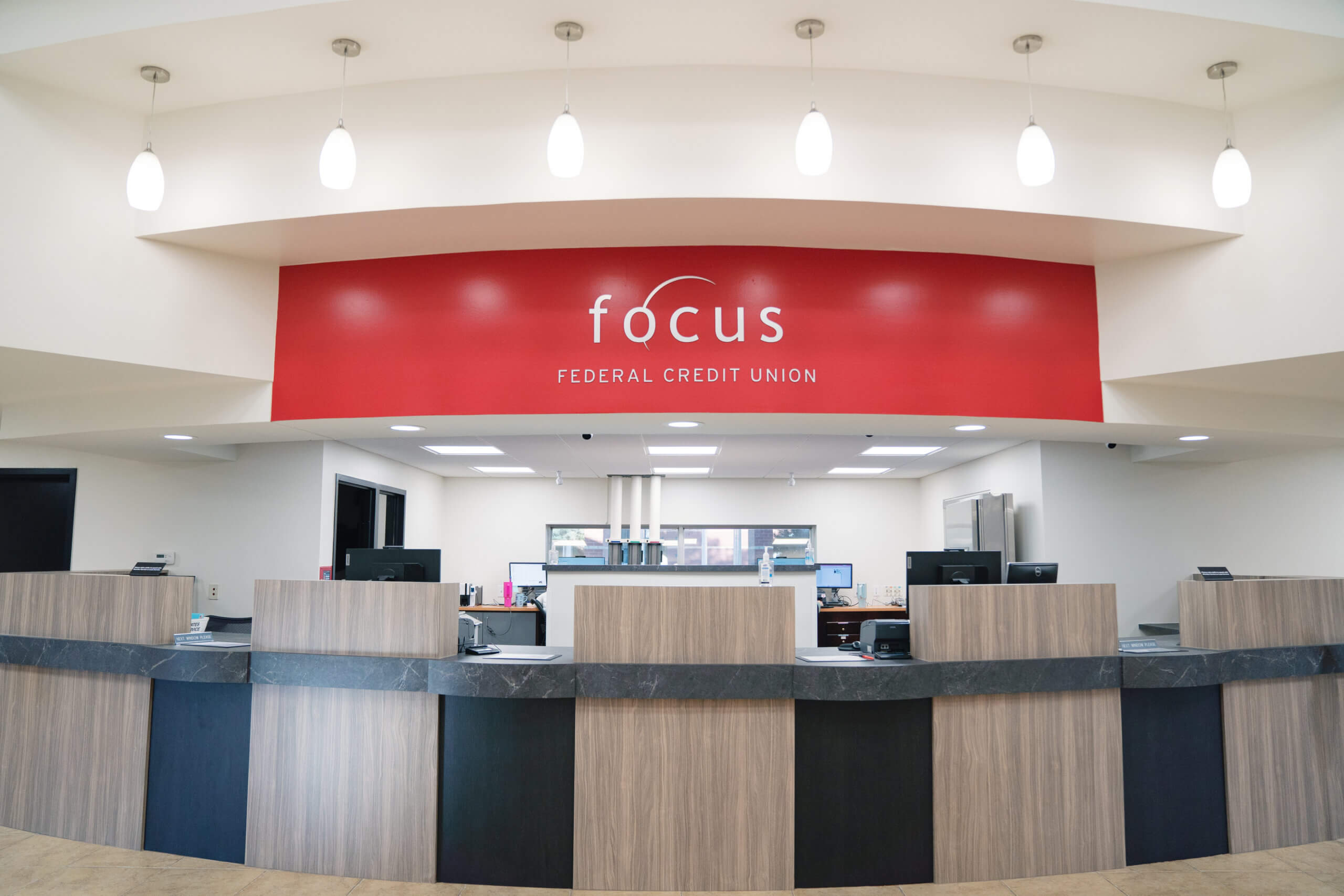 Federal credit union branch interior with teller counters and a red Focus Federal Credit Union sign