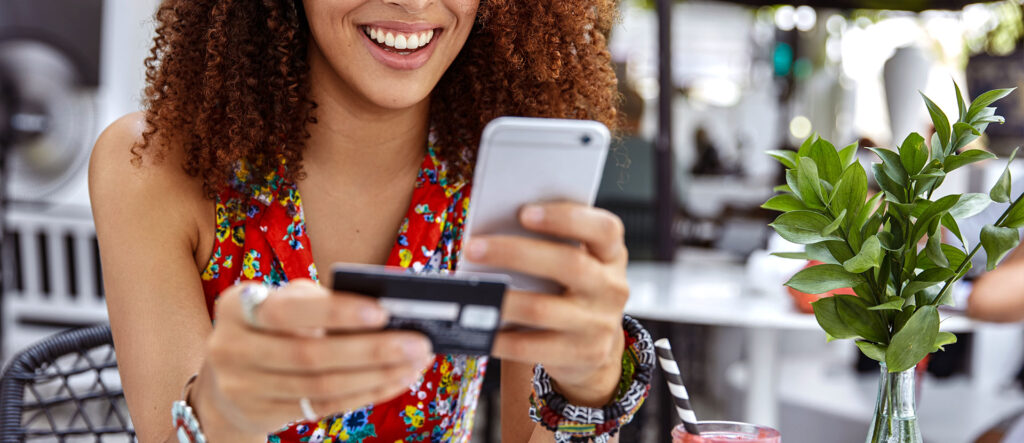 Woman using her phone and debit card